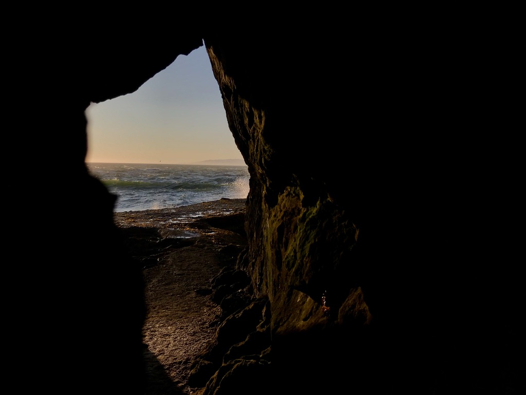 My photograph of the ocean seen through a dark rock opening in San Francisco.